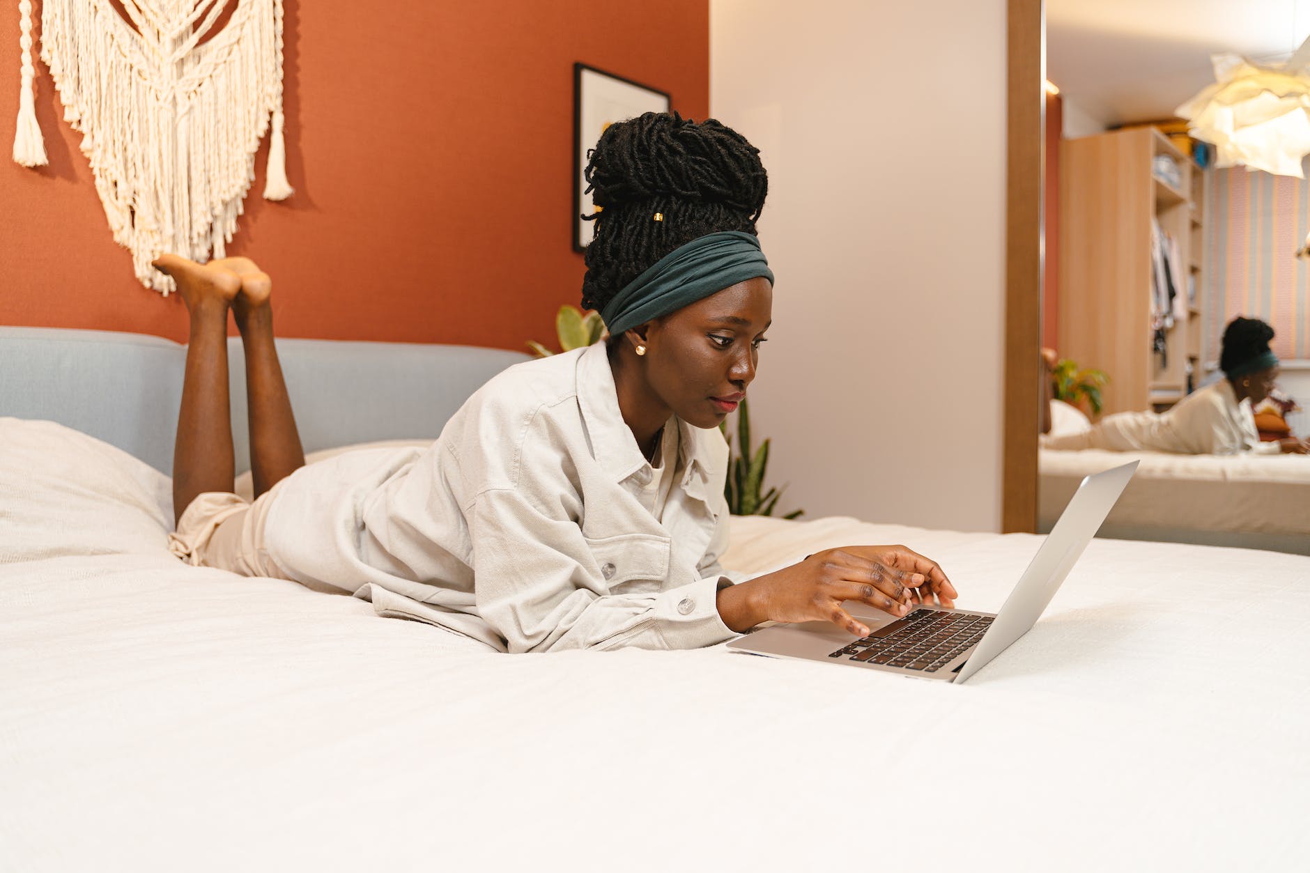 woman lying on bed with laptop