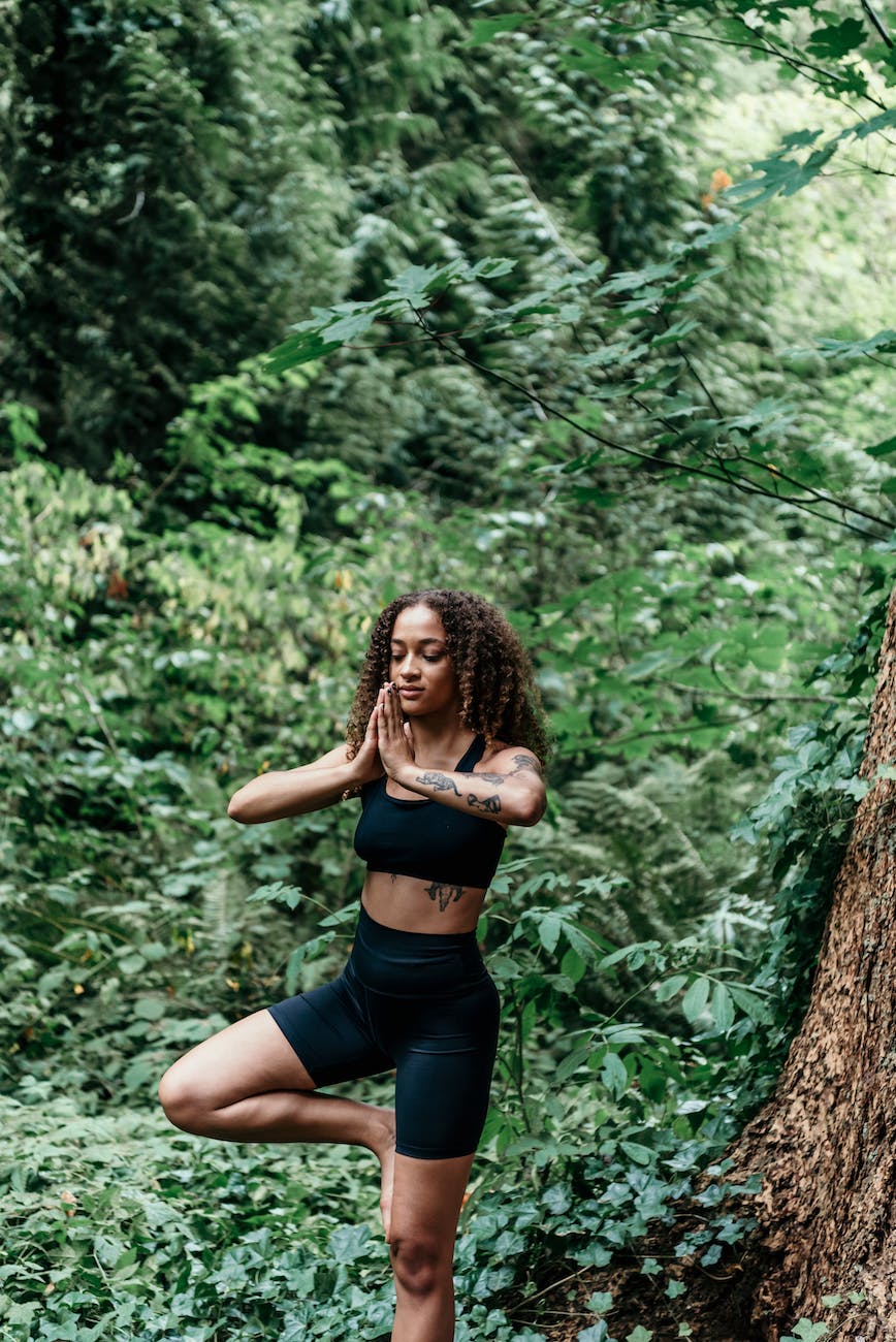 woman in black activewear meditating outdoors