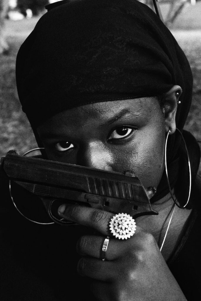 woman wearing a headscarf holding a gun