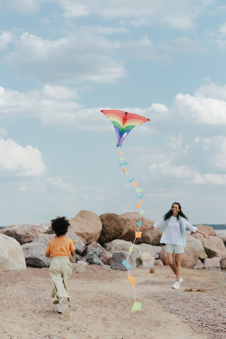 a young girl and a woman playing a kite together