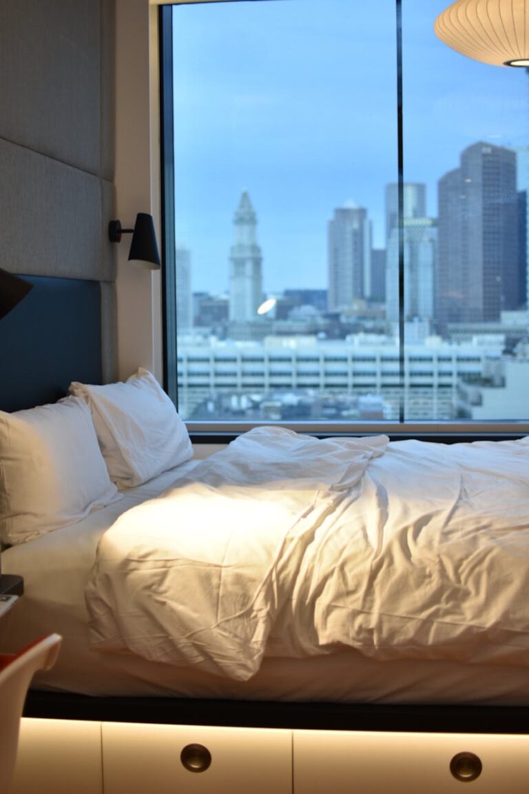 white pillows on bed beside window