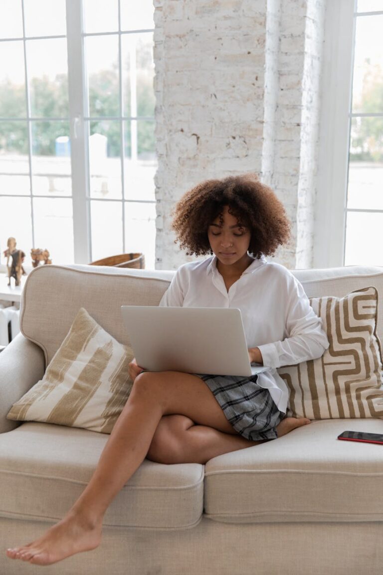 focused young african american lady working online on netbook at home