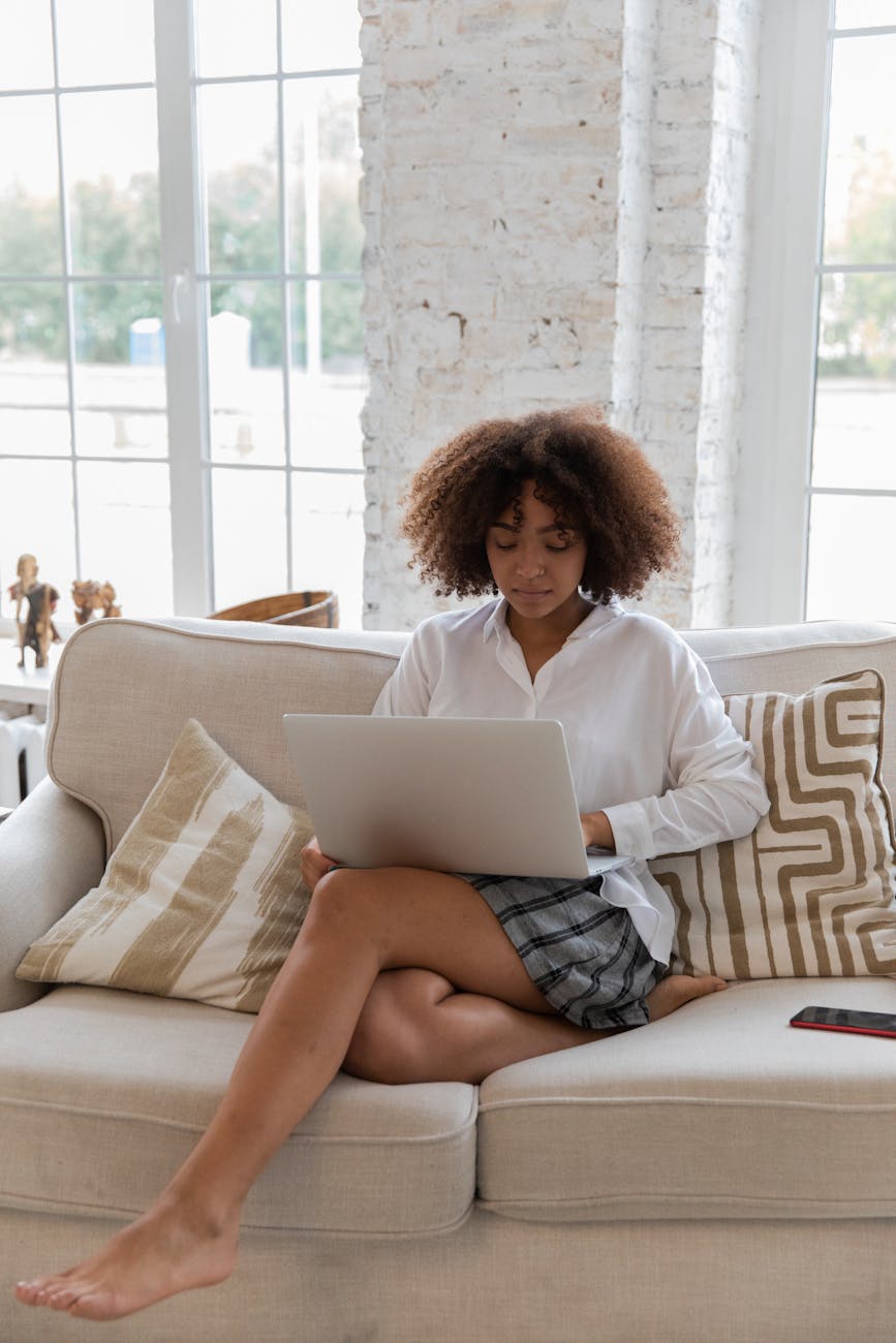 focused young african american lady working online on netbook at home