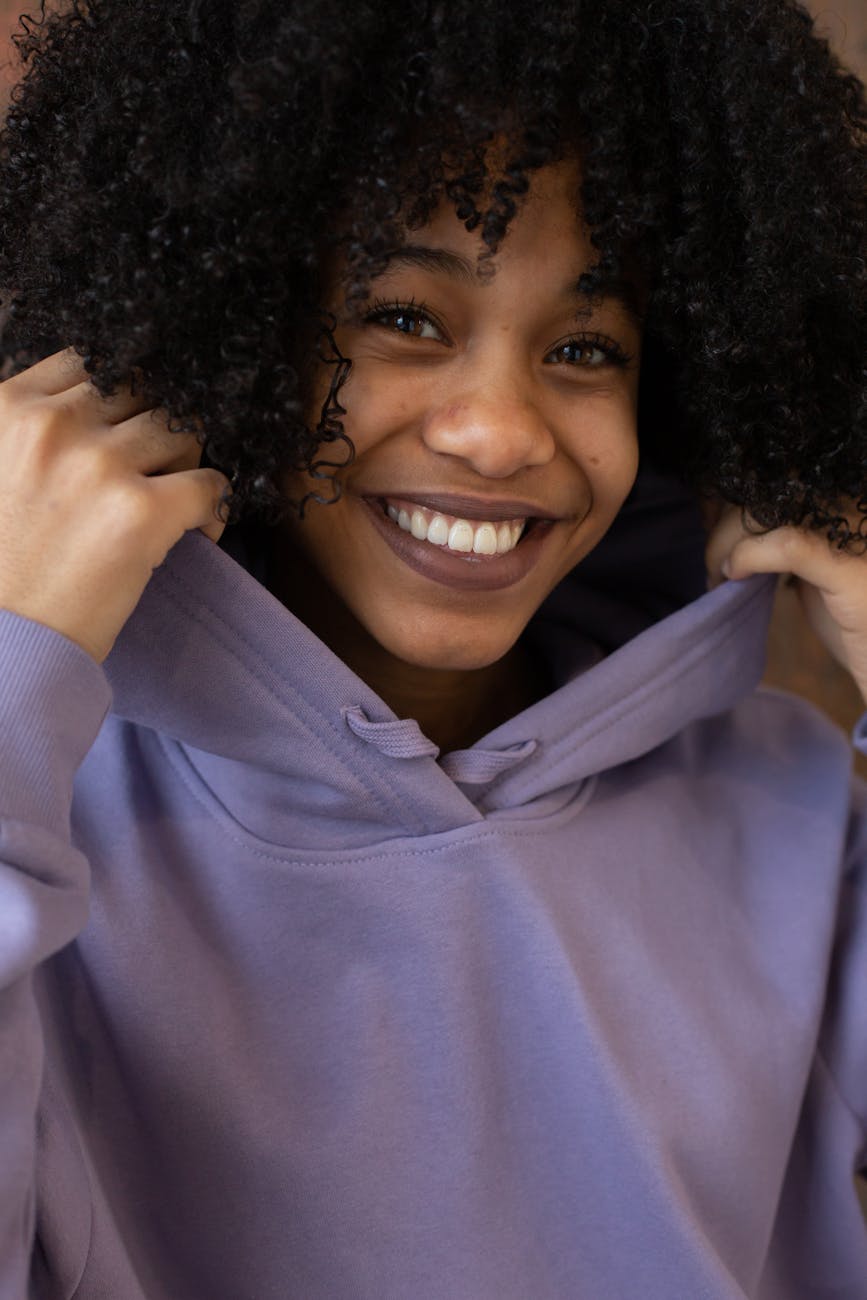 smiling african american woman wearing hoodie looking at camera