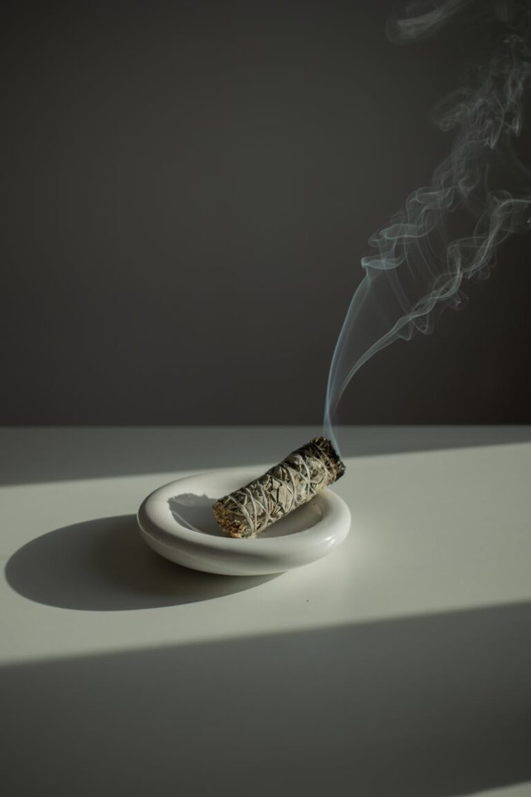 a burning incense on a white plate standing on a white table