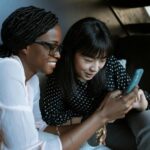 woman in black and white polka dot shirt holding smartphone