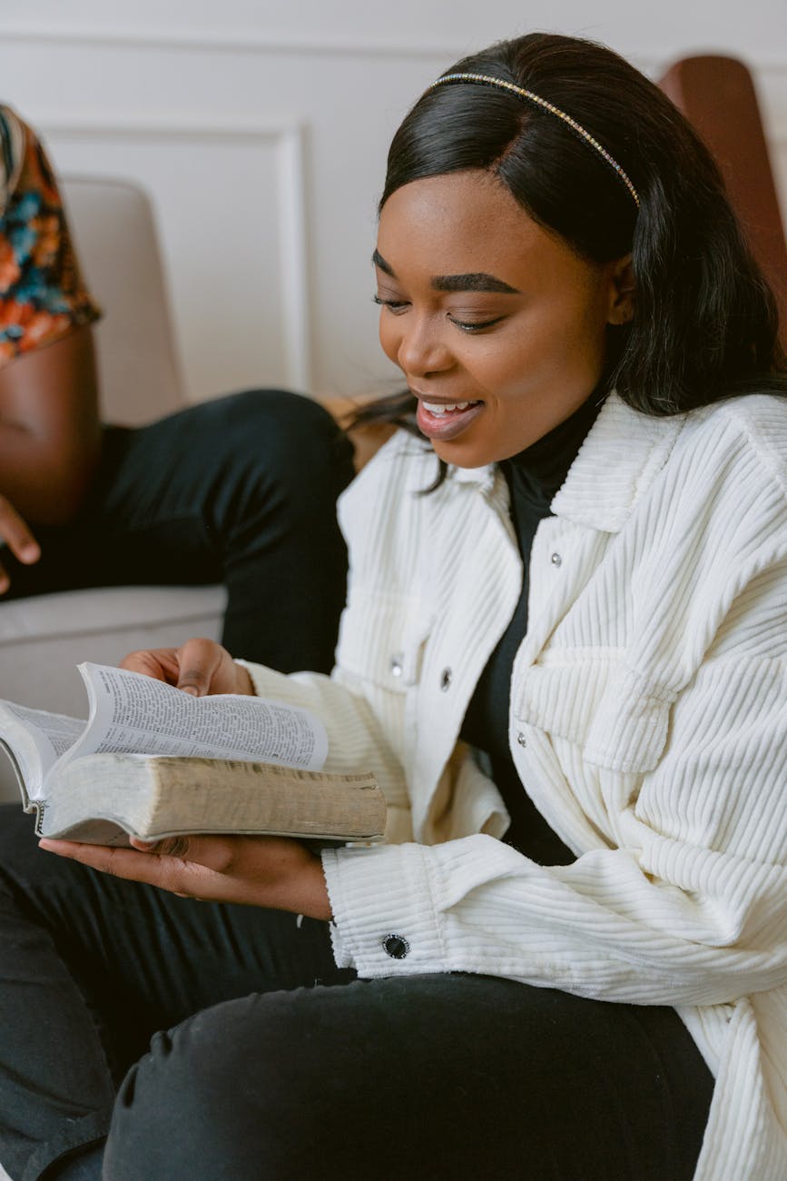 woman in white jacket reading bible