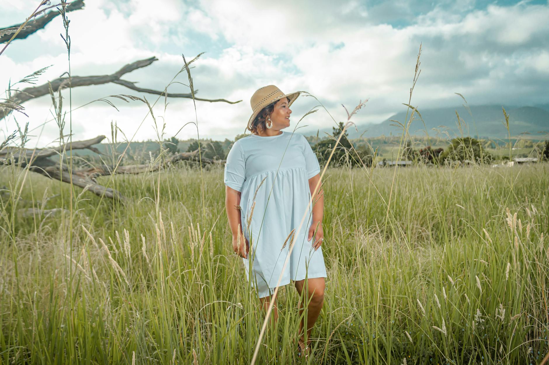 woman in white t shirt dress standing on green grass field