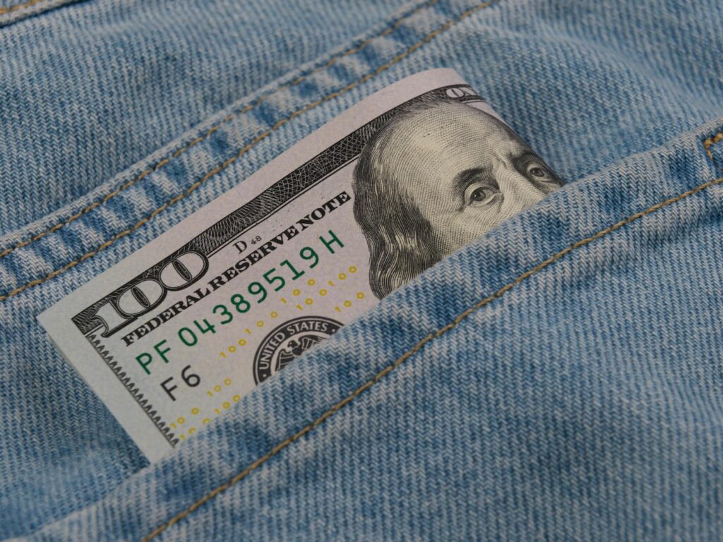american one hundred dollar banknote in pocket of blue jeans